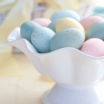 a white bowl holding speckled Easter eggs